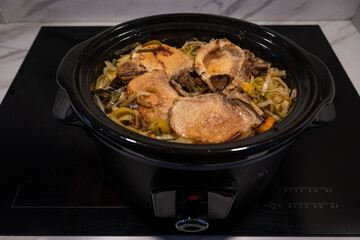 pork soup food in the slow cooker meat and vegetables spend hours slowly cooking through to make a tasty hearty winter broth. crockpot pan has no lid to show meal ingredients