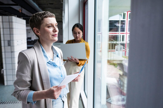 Businesswomen collaborating in modern office near window