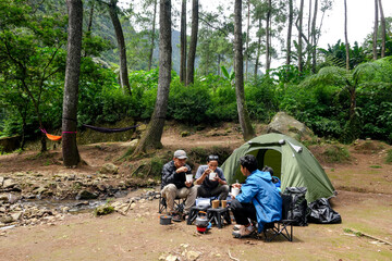 Friends Enjoy Peaceful Camping Trip Amidst Greenery of Forest