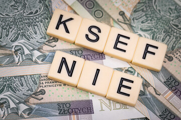 Blocks with the abbreviation KSEF NO, standing for negatives about National E-invoice System, are placed against a background of loosely spread Polish 100 PLN banknotes. 
