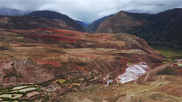 Sacred Valley Maras Salt Mine Peru Per&uacute; aerial drone Salineras de Maras rainy season cloudy Peruvian Andes Mount Patacancha Moray Chic&oacute;n Ancopacha Ollantaytambo Cusco region forward pan up motion