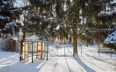 Tranquil winter countryside scene with a swing in the garden on a sunny day.