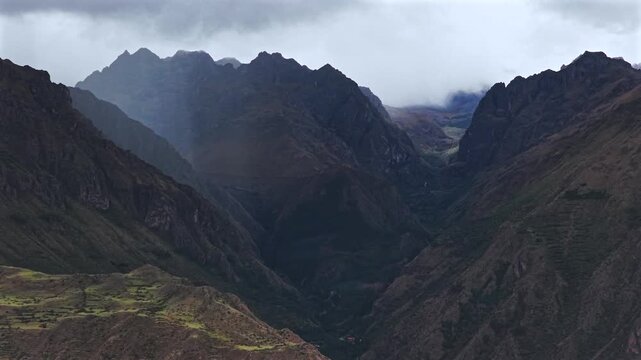 Peruvian Andes canyon Mount Patacancha Cuncani Pumahuanca glacier Sacred Valley Chic&oacute;n Peru Per&uacute; aerial drone rainy season snow clouds Quelccaya Urubamba range cusco region backwards pan up motion
