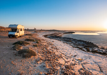 Camper van parked on rocky coastline at sunset in Djerba Tunisia, remote travel lifestyle, quiet seascape, freedom, adventure, vanlife