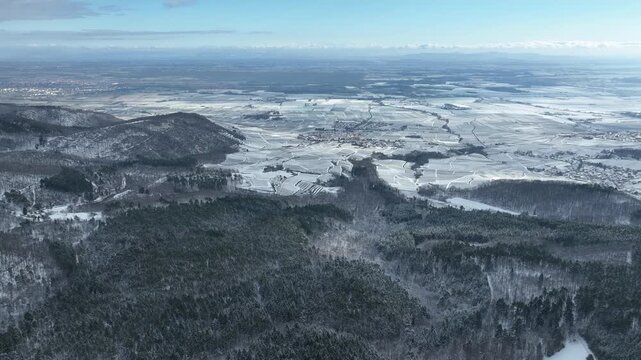 Aerial view of Orschwiller reveals a landscape swathed in white snow, contrasting with the dark evergreens and clear sky, Orschwiller, Grand Est, France.