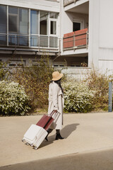 Female walking with suitcase and tote bag