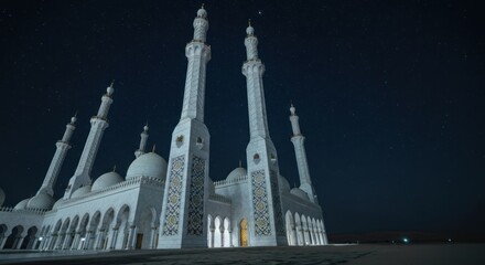 Obraz premium A large white mosque with multiple minarets and domes at night