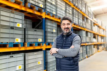 Male warehouse supervisor in hard hat with clipboard and scanner. Logistics manager looking at...