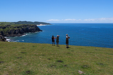 A family stands at a view point overlooking the ocean