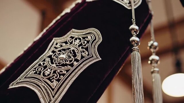 Close-up of a Torah scroll being lifted, highlighting sacred craftsmanship and reverence.