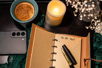 Cozy workspace with to-do list, coffee and candles &ndash; planning and mindfulness concept
