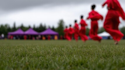 Obraz premium A group of people in red robes running on a grassy field.