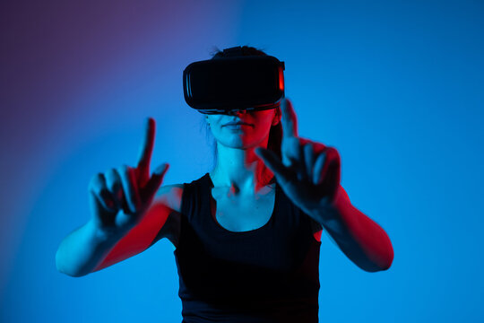 Female user wearing VR headset controlling virtual interface with both hands gestures - Powered by Adobe