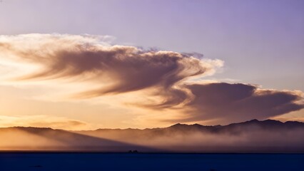 Colorful cloud formations glowing in the evening sky during sunset, creating a dramatic and artistic atmospheric scene.