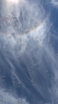 blue sky filled with wispy clouds and bubbles slowly floating past