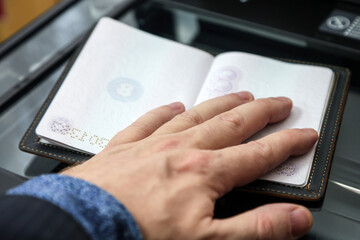 Copying Passport Pages at a Document Copy Center &ndash; Office Administrative Service. A man's hand holds document.