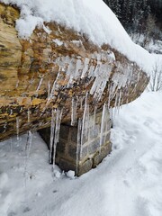 Icicles hanging from snowy wooden roof in winter