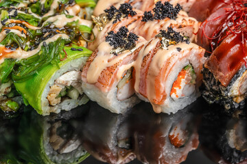 Luxury sushi rolls with salmon tuna caviar and gold leaf on dark background © Надія Коваль