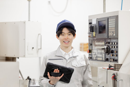 工場の操作盤の前で働く男性作業員