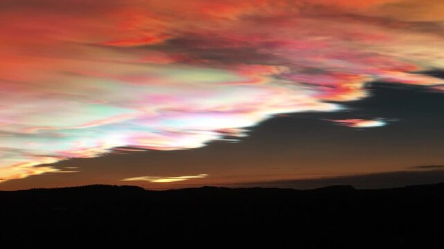 Aerial view of iridescent nacreous clouds painting the sky with ethereal hues above the dark silhouette of the horizon, Lapland, Finland.