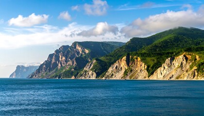 Dramatic Coastal Cliffs Meeting the Azure Sea Under a Cloudy Sky.