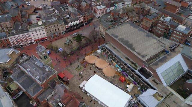 Aerial view of the bustling Derby Market Place showcasing the Guildhall, clock tower, and vibrant market stalls, Derby, England, United Kingdom.