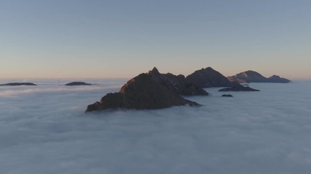 Aerial view of jagged, rocky peaks of Dent de Jaman pierce through a sea of dense, ethereal clouds, creating a breathtaking contrast of textures, Montreux, Vaud, Switzerland.