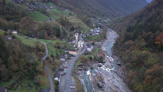 Aerial view of the Verzasca river flowing through the valley, with the village and church nestled amidst the landscape, Lavertezzo, Ticino, Switzerland.