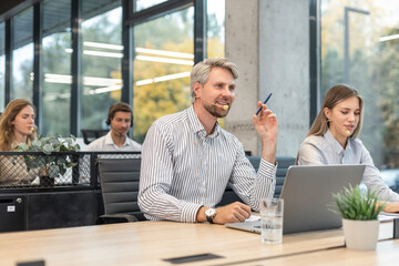 Customer service representatives engaged in professional work using headsets and laptops