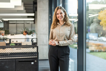 Confident stylish european woman standing at workplace, executive leader manager smiling.