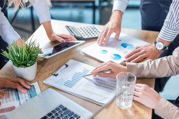 Business team analyzing income charts and graphs with modern laptop and digital tablet.