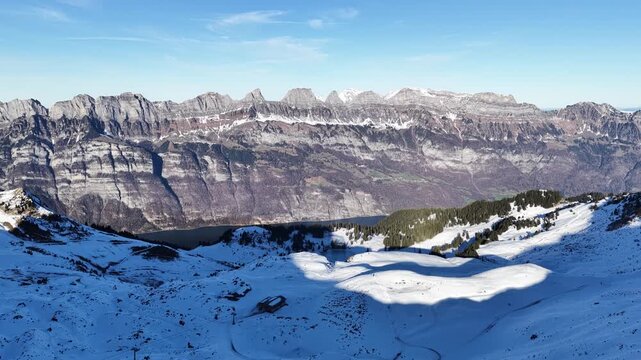Snow covered alpine mountains and ridges overlooking Walensee in daylight