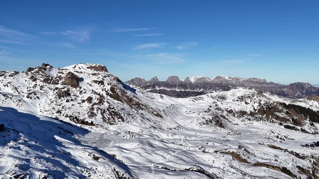A sweeping aerial view of the Swiss Alps, showcasing the snowy slopes of Flumserberg and the iconic Churfirsten peaks. A majestic landscape of Flums in winter.