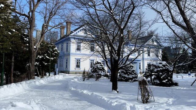 Historic white mansion seen through leafless winter trees