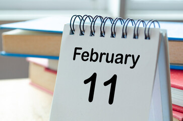 February 11 desk calendar on a clean workspace background