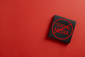 Black sticky note with crossed out social media text on red background. Concept of digital detox,...