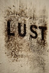 Extreme macro photograph of the word "LUST" typed on thick cream paper, mechanical type pressure visible, organic paper grain