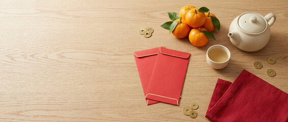 Red envelopes, mandarin oranges, and tea set arranged on wooden table for Lunar New Year celebration with copy space