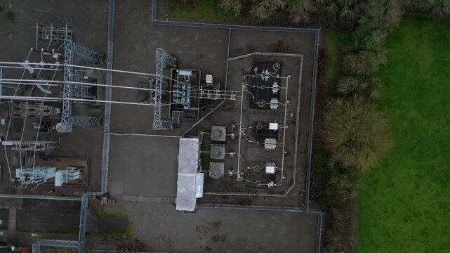 Aerial view of the electrical substation with complex machinery and buildings contrasting against the green fields and road, Melton Mowbray, England, United Kingdom.