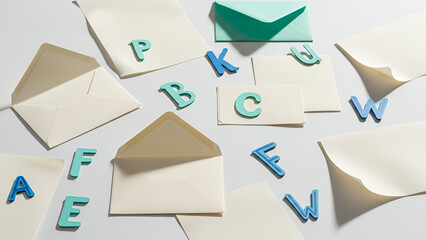 Playful arrangement of hand-written letters and colorful envelopes with letter blocks on soft background