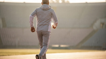 Senior Man Running at Stadium Track, Active Lifestyle and Healthy Aging