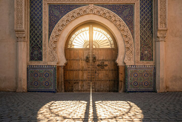 Puerta tradicional marroqu&iacute; con arco &aacute;rabe y mosaicos al atardecer