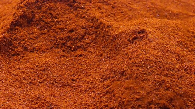 Vibrant red chili powder pouring, spicy food texture