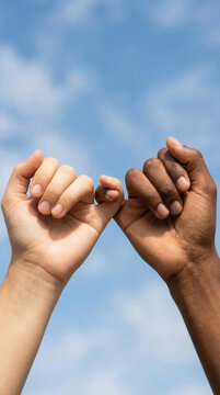 Unity and friendship concept with diverse hands interlocked against sky