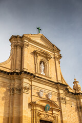 The grand facade of the Cathedral of the Assumption in the Cittadella of Victoria, Gozo, featuring wide stone steps and baroque limestone architecture. Travel to Malta.