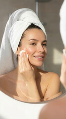 Woman practicing skincare routine with cotton pad in the bathroom for healthy skin