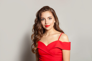 Perfect fashion model woman with shiny skin, wavy hairstyle and red lips makeup on black background