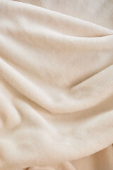 Fototapeta premium Soft beige fabric draped elegantly, showcasing texture and warmth