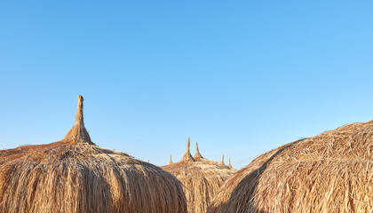 Straw umbrellas on the beach in Hurghada, selective focus, Egypt.