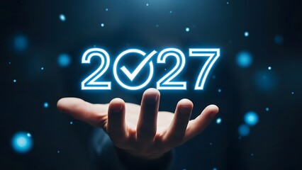 Hand holding glowing 2027 with checkmark in zero